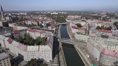 Flight-over-the-river-flowing-through-the-historic-part-of-Olomouc,-bridges,-streets-and-the-cathedral