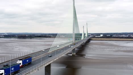 Mersey-gateway-landmark-aerial-view-above-toll-suspension-bridge-river-crossing-rising-left-dolly-shot