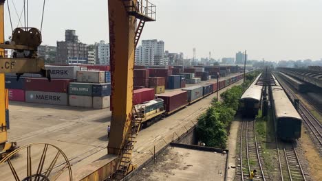 Lagerhaus,-In-Dem-Ein-LKW-Einen-Container-Zum-Verladen-Auf-Den-Güterzug-Bringt,-Und-Ein-Bahnhof-In-Komlapur,-Bangladesch-–-Schwenkansicht-Von-Links-Nach-Rechts