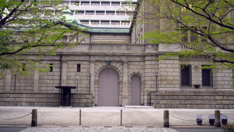 Tokio,-Japón,-Alrededor-De-Abril-De-2020:-Gente-Montando-En-Bicicleta-Frente-A-Un-Edificio-Protegido,-Banco-De-Japón,-En-El-Centro-Antiguo-Del-Distrito-Financiero-Central,-Día-De-Primavera