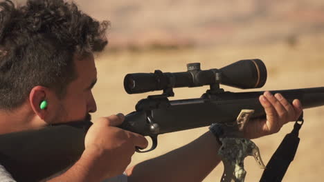 Close-up-of-a-hunter-aiming-through-a-scope-for-a-target-and-shooting