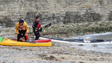 Group-of-males-kayak-training-team-exercise-on-Welsh-sea-shore