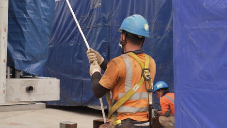 Manual-Worker-Holding-Rope-And-Rigging-At-The-Construction-Site