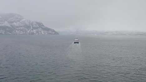 Ferry-Navegando-En-El-Norte-De-Noruega-En-Un-Día-Nublado-De-Invierno,-Vista-Aérea