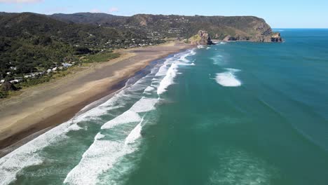 Volando-Por-La-Famosa-Playa-De-Arena-Negra-Piha-En-Nueva-Zelanda-Durante-La-Marea-Baja