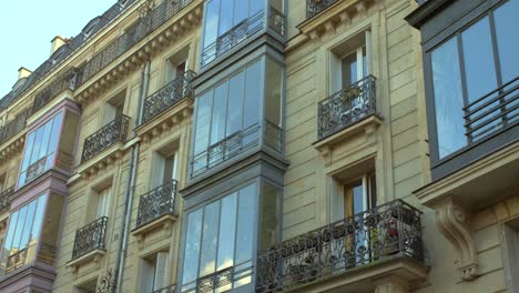Vista-De-Las-Modernas-Ventanas-De-Proa-Del-Exterior-De-La-Fachada-De-La-Arquitectura-Haussmanniana-En-París,-Francia