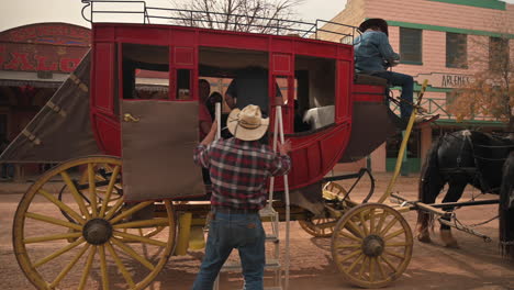 Tombstone-Arizona,-a-guide-is-helping-people-into-the-stagecoach,-getting-ready-for-their-ride-on-famous-Allen-Street