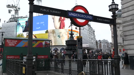 Schild-Der-U-Bahn-Station-Piccadilly-Circus-Mit-Berühmten-Werbetafeln-Im-Hintergrund