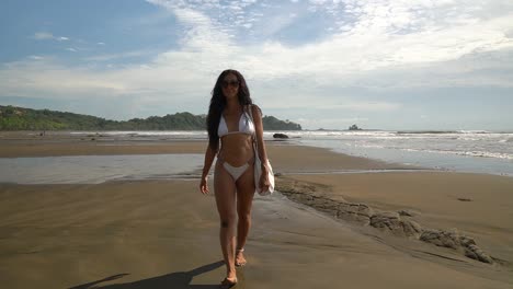 Beautiful-female-model-walking-in-slow-motion-on-tropical-sand-beach