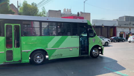 Green-Coloured-La-Buseta-Bus-Travelling-Along-Busy-Road-In-Mexico-City