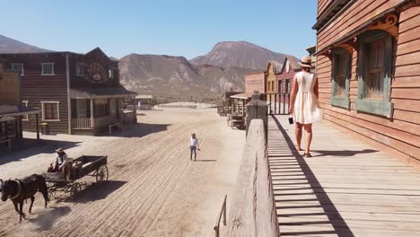 Girl-and-horse-riding-cowboy-at-Oasis-Mini-Hollywood-in-the-Tabernas-Desert-in-Almeria,-Andalucia,-Spain