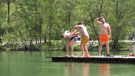 Guys-having-fun-and-jumping-in-the-lake-of-Jasna-in-Kranjska-Gora-in-Slovenia-at-100-fps,-slow-motion