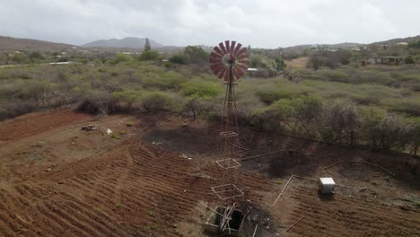 The-windmill-water-pump-on-a-farm-deserted-due-to-global-warming---aerial-drone-shot