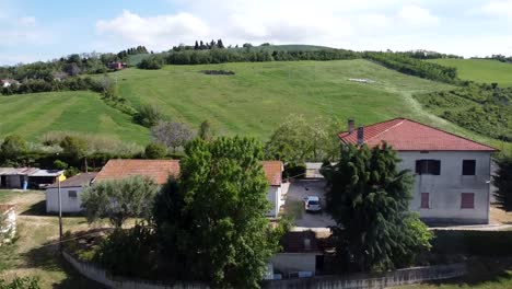 Aerial-shot-of-an-estate-in-a-hilly-field-landscape-in-central-Italy