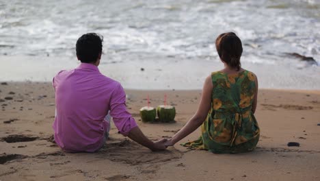 Back-view-of-man-holding-woman-hand-on-the-beach-of-Diu-city-of-India-with-slow-motion-of-waves