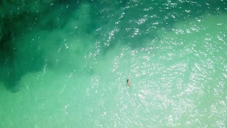 Top-View-Of-A-Woman-Swimming-On-Blue-Ocean-Of-Kenya-Coast-In-Africa