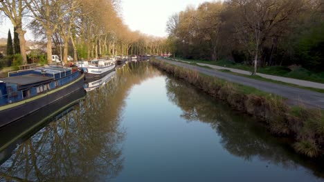 Vista-De-Drones-De-Las-Casas-Flotantes-En-El-&quot;canal-Du-Midi&quot;-A-Lo-Largo-De-La-Ciudad-De-Toulouse,-En-Una-Soleada-Mañana-De-Primavera