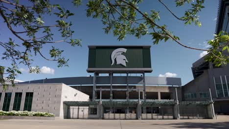 Exterior-Del-Estadio-Espartano-En-El-Campus-De-La-Universidad-Estatal-De-Michigan-En-East-Lansing,-Michigan-Con-Movimiento-Lento-De-Izquierda-A-Derecha-Mostrando-árboles