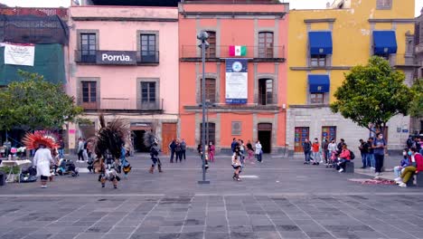 Coyoacán-Tänzer,-Traditionelle-Mexikanische-Tänze,-Indigene-Tragen-Federkronen-Auf-Dem-Platz-Mit-Bunten-Kolonialhäusern-Im-Hintergrund