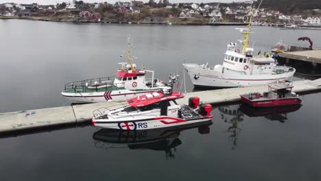 Tres-Generaciones-De-Botes-De-Rescate-Sar-De-Redningsselskapet-Company---Antena-Girando-Alrededor-De-Botes-En-Lillesand-Marina-Noruega