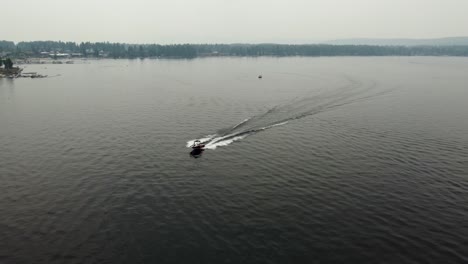 Drone-shot-of-a-speed-boat-driving-towards-the-camera-at-Lake-Payette-in-McCall,-Idaho