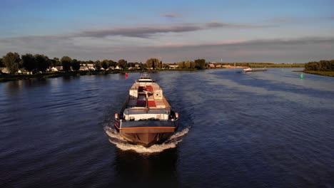 Aerial-View-Of-Forward-Bow-Of-FPS-Waal-Cargo-Container-Vessel-Travelling-On-Oude-Maas-During-Golden-Hour