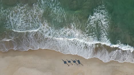 Surfers-shadow-walking-on-beach-sand