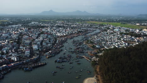 Overpopulated-Vietnamese-town-with-huge-fishing-industry,-aerial-orbit-view