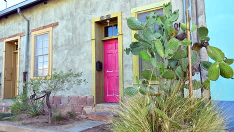 Casa-De-Adobe-Antigua-Y-Colorida-Con-Puerta-Rosa-Y-Cactus-Verde-En-La-Comunidad-De-Barrio-Viejo-De-Tucson,-Arizona