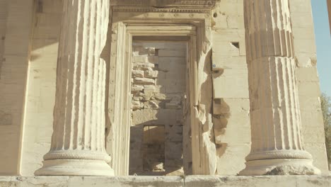 Ancient-pillars-holding-up-the-Erechtheion,-Tilt-Down-Reveal-Shot