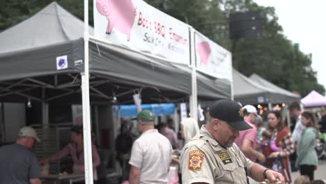 Gusto-Del-Oficial-De-Seguridad-De-Madison-E-Inclinación-Hacia-Arriba-Para-Firmar-El-Cerdo-A-La-Barbacoa