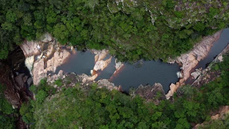 Aerial-drone-top-down-shot-of-the-incredible-Mosquito-Falls-with-the-river-leading-to-the-falls-surrounded-by-tropical-jungle-and-cliffs-in-the-Chapada-Diamantina-National-Park-in-Northeastern-Brazil