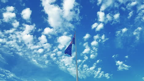 Australische-Flagge-Weht-Im-Wind-Vor-Einem-Wolkenverhangenen-Blauen-Himmel---Niedriger-Winkel,-Zeitlupe