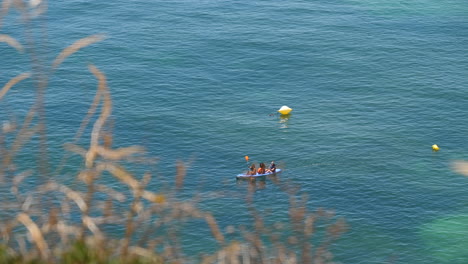 Tourists-paddling-in-a-kayak-in-the-turquoise-sea-of-Benagil-Portugal