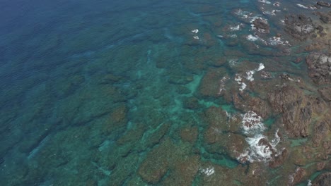 Flying-over-coral-reef-at-Tsukasaki-Tidal-Pools-in-Yakushima-Japan-on-Sunny-Day