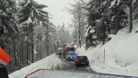 Snow-Plow-clears-road-where-truck-is-stuck-on-snowy-road