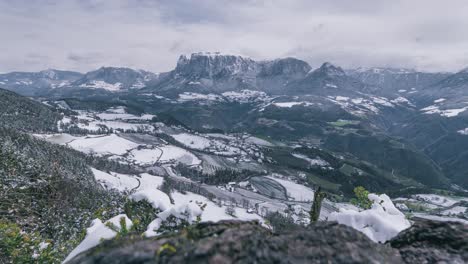 Timelapse-De-La-Montaña-Con-El-Pueblo-Cercano-Cubierto-De-Nieve-Durante-La-Primavera