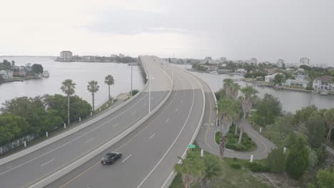 Porsche-sports-car-drives-on-bridge-at-Tampa-Bay-aerial-scenery,-St-Petersburg