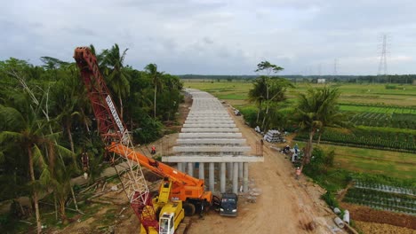 Aerial,-concrete-pillars-on-monorail-construction-site-in-Yogyakarta,-Indonesia