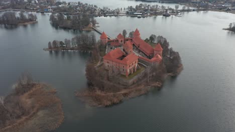 Antena:-Toma-Giratoria-Del-Castillo-De-La-Isla-Trakai-De-Color-Rojo-Rodeado-De-Lago-Y-Casas-En-La-Distancia