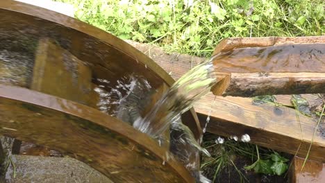 Wasser-Fließt-Auf-Einer-Rotierenden-Moosigen-Wassermühle-Am-Fluss-Auf-Dem-Land