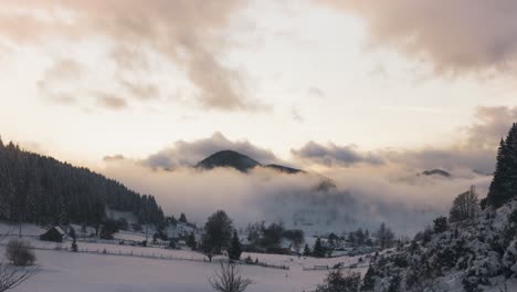 Paisaje-Nevado-Con-Un-Pueblo-Tranquilo-Cerca-De-Una-Montaña-Boscosa-Bajo-Un-Cielo-Nublado-Durante-La-Puesta-De-Sol