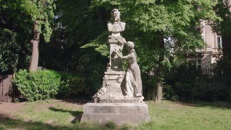 Panning-across-Statue-of-Edouard-Pailleron-by-Leopold-Bernstamm-in-Parc-Monceau-in-Paris,-France