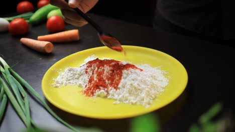 Adding-paprika-powder-to-flour-mixture,-masala,-spices
