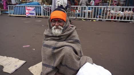 Älterer-Indischer-Bettler,-In-Eine-Decke-Gehüllt,-Sitzt-Auf-Dem-Boden-Und-Bittet-Um-Almosen