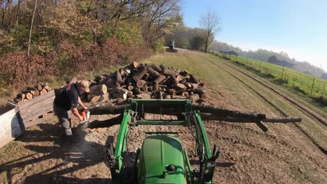 Man-using-a-chain-saw-to-cut-a-log-into-pieces-to-fit-into-a-fireplace