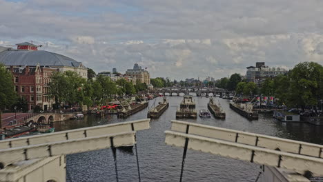 Amsterdam-Netherlands-Aerial-v21-low-level-drone-flyover-multiple-bridges-crossing-amstel-river-capturing-the-romantic-cityscape-of-weesperzijde-and-jeruzalem-neighborhoods-at-daylight---August-2021