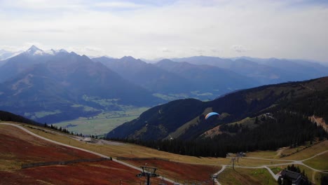 Paraglider-Passes-By-The-Gondola-Tower-At-The-Schmittenhohe-Mountain-In-Salzburg,-Austria