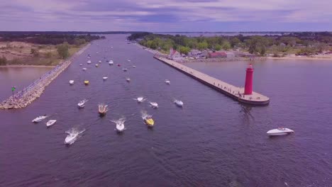 Aerial-pan-of-powerboats-cruising-through-Muskegon-channel-in-Michigan