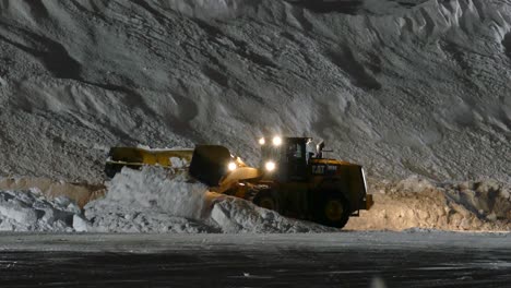 Excavadora-Amarilla-Con-Un-Arado-De-Nieve-Limpia-Y-Empuja-La-Nieve-Sobre-Una-Pila-Enorme,-Estática